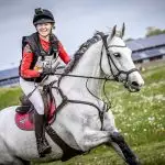 Ruiter in Actie met Florian Horsefood Ruiter op paard in open veld, Florian Horsefood, natuurlijke paardenvoeding.